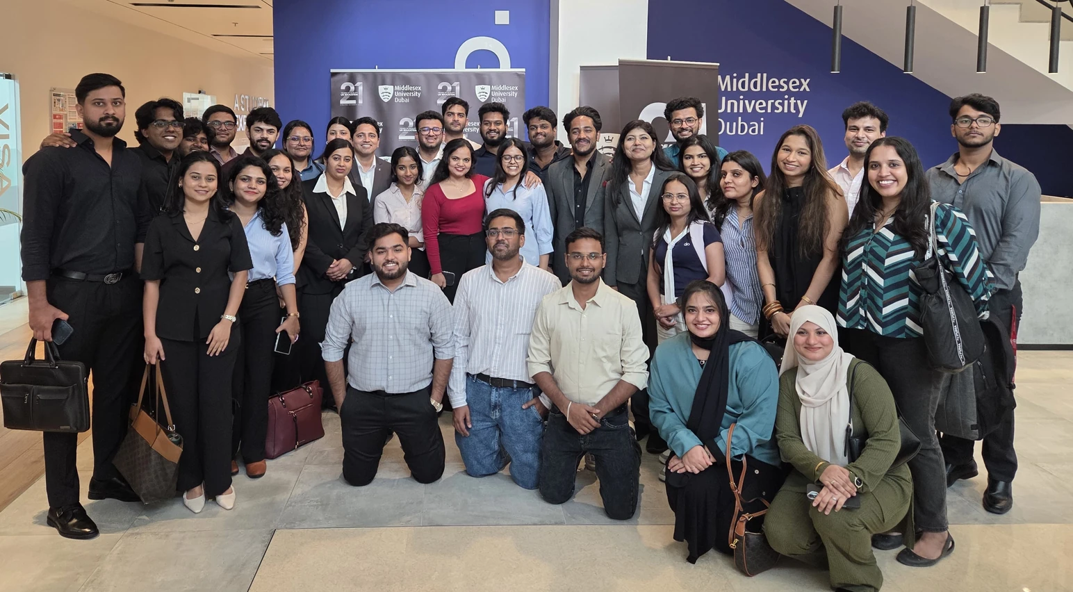 Amresh with his MBA cohort in front of the Middlesex University Dubai wall
